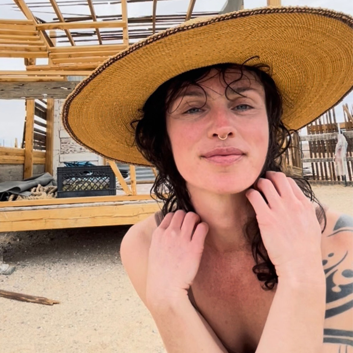 Renee Sills color portrait. Renee is posed outside at a beach, wearing a sun hat and is smiling.