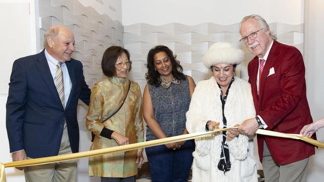 Photo of five people cutting a ribbon