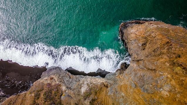 Coastal cliff with greenish-colored water