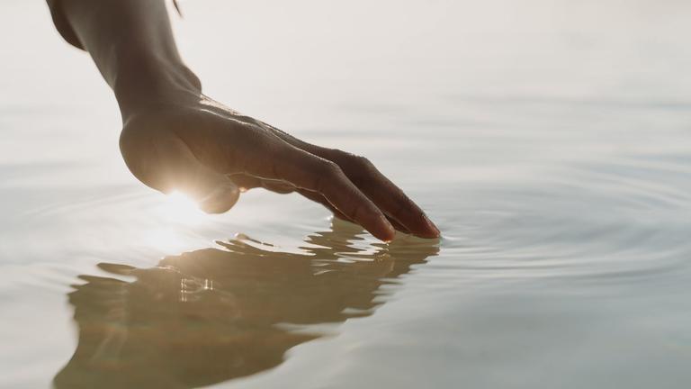 Hand of black man touching the water by Cottonbro Studios