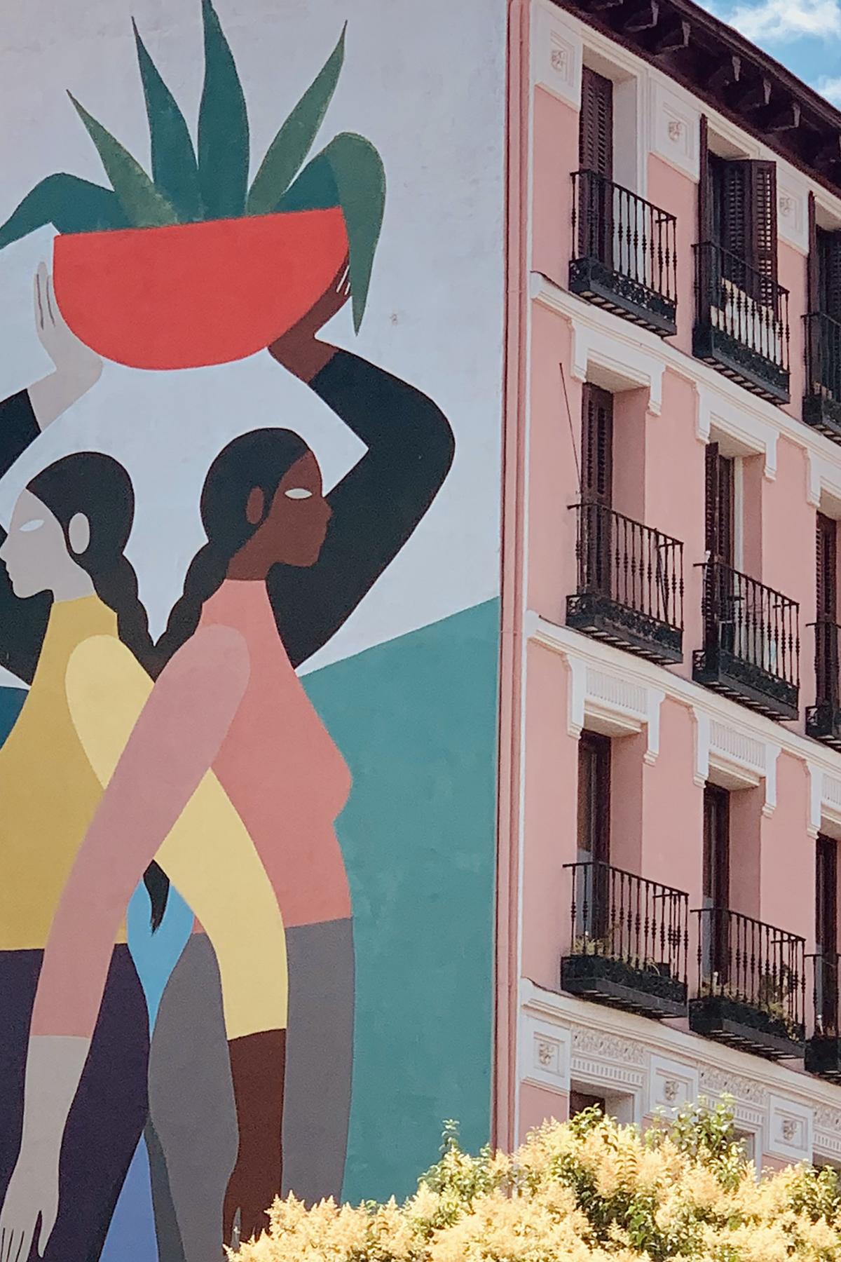 Mural of two women holding a potted plant over their heads