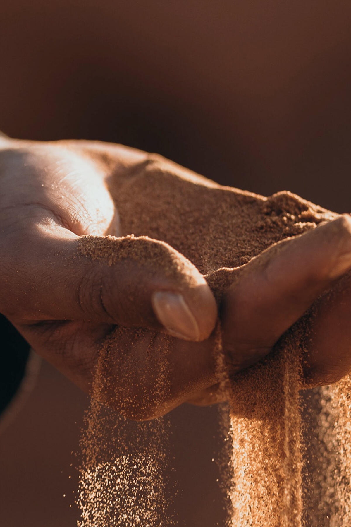 Photo of a hand with sand flowing between the fingers