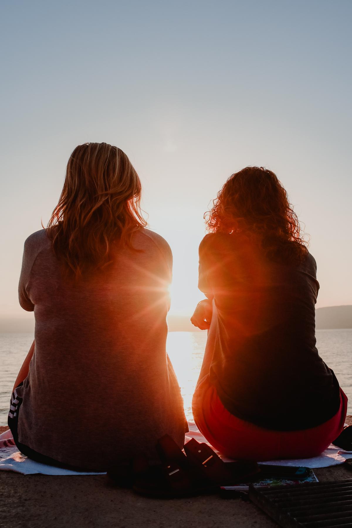 Friends sitting with the sun shining between them