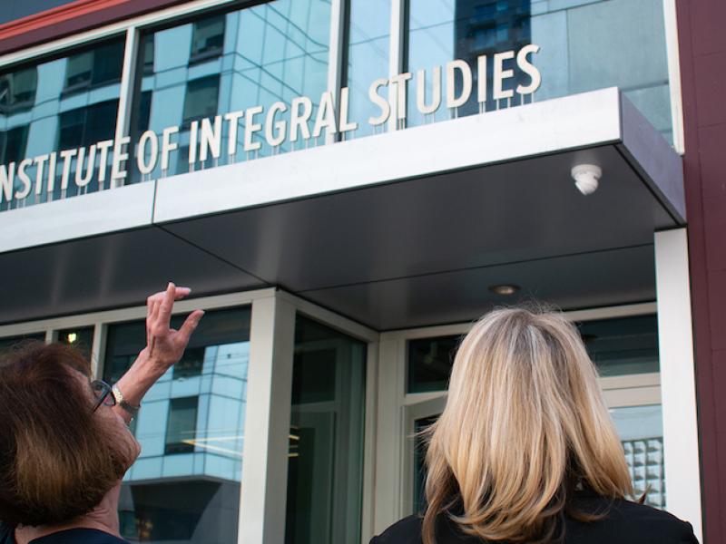 Two CIIS staff members standing in front of CIIS main campus building.