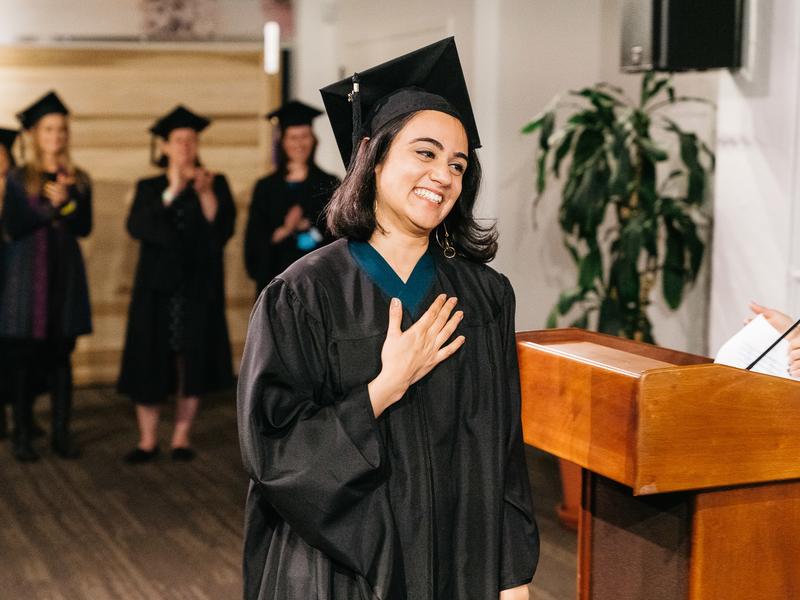 graduate holding heart as accepting degree at graduation