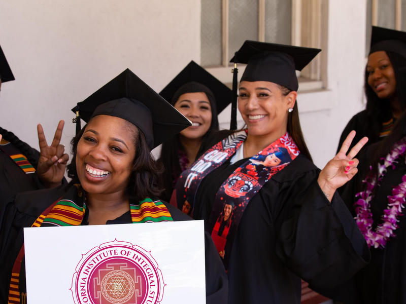 Photo of six women in graduation cap and gown